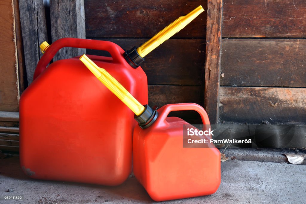 Two Red Plastic Gas Canisters An image of two red plastic gas canisters. Gas Can Stock Photo