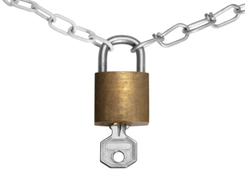 studio photography of a closed padlock with key and chains, isolated on white with clipping path