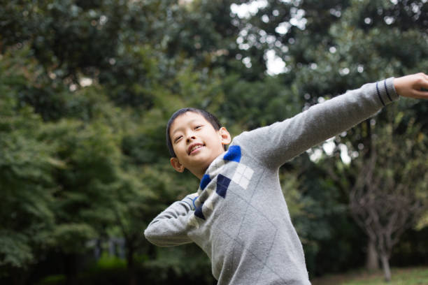 istock chinese boy playing paper airplane 959418436