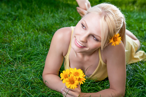 Blonde woman with yellow daisy