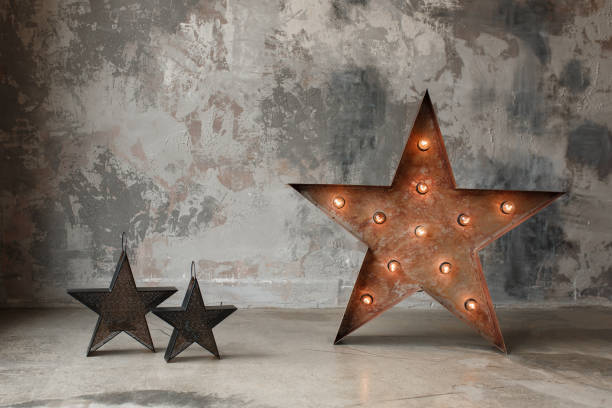 istock Big star with bulb lights and small one on concrete wall background, loft interior decor. Copy space for text 959438288