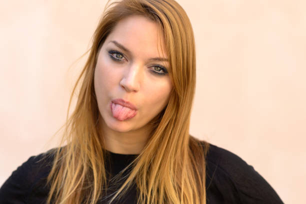 istock Blond woman sticking out her tongue 959442016