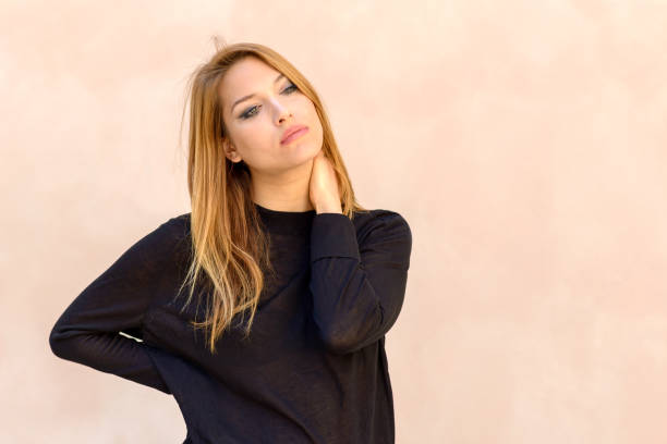 natural portrait of a beautiful young woman - touching neck imagens e fotografias de stock