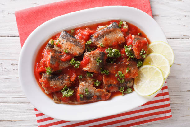 istock Braised sardines in tomato sauce with lime and parsley close-up. horizontal top view 959442942