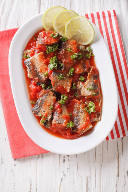 istock sardines in tomato sauce, decorated with lime and parsley close-up. vertical top view 959443364