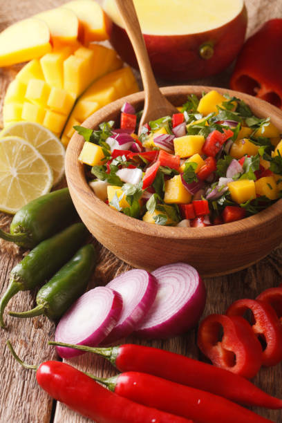 istock Mexican salsa with mango, pepper, jalapeno, cilantro and onions close-up. vertical 959443970