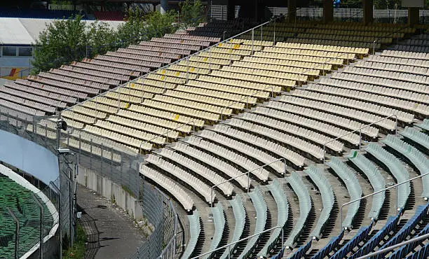 detail of a tribune on a racetrack named "Hockenheimring" in Southern Germany with lots of colored chairs at summer time