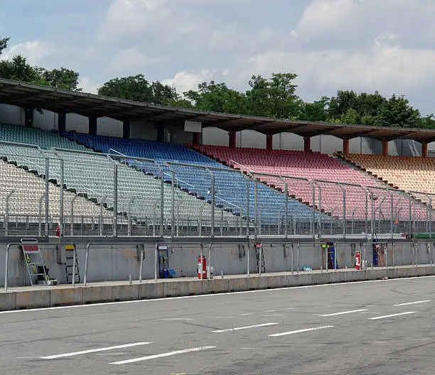 detail of a racetrack named "Hockenheimring" in Southern Germany with multi colored tribune and security fence