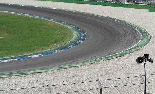 curve scenery on a racetrack named "Hockenheimring" in Southern Germany with wheel traces and run-off area