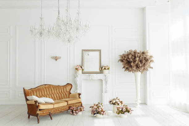 istock beautiful classical white interior with a fireplace, brown sofa and a vintage chandelier. Retro, classics horizontal view 959447396
