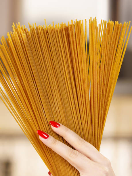 istock Woman hand holding pasta 959448618