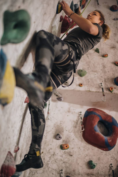 istock Below view of female athlete practicing climbing on a wall in bouldering gym. 959448814