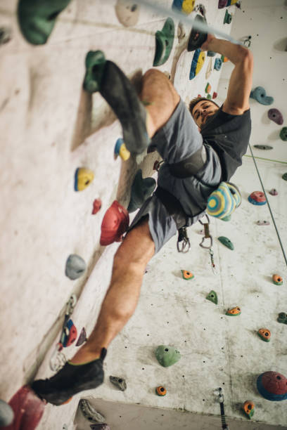 istock Low angle view of athletic man climbing on the wall in a gym. 959449184