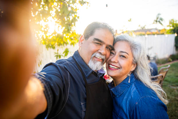 istock Senior Mexican Couple taking a selfie at BBQ 959451360