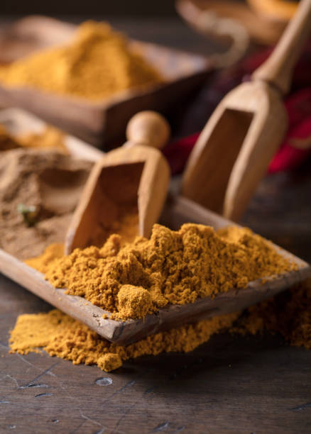 istock Various Indian spices with wooden spoons on a wooden table. 959459116