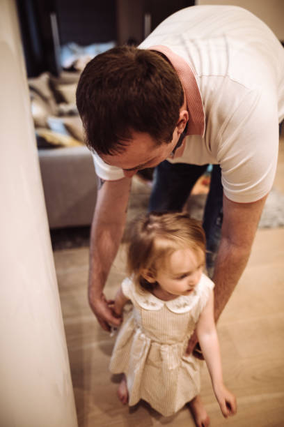 istock dad help the daughter to walk 959462748