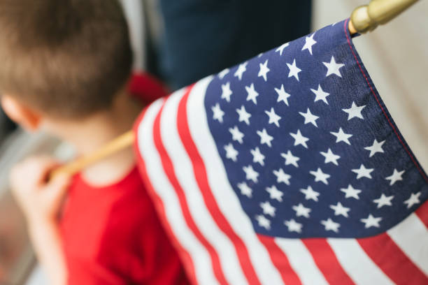 istock Young boy holding USA flag over shoulder 959464606