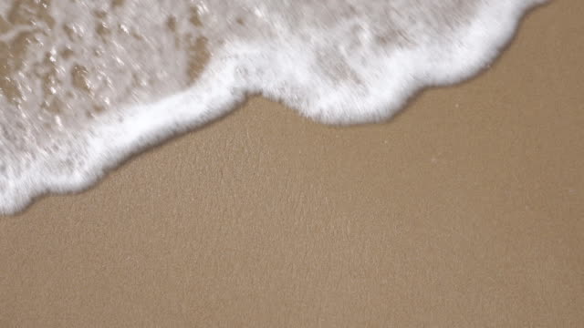 Slow motion foam wave on the beach