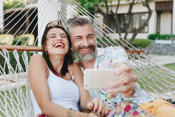 coppia che si fa un selfie mentre è in vacanza - summer vacations women hammock foto e immagini stock