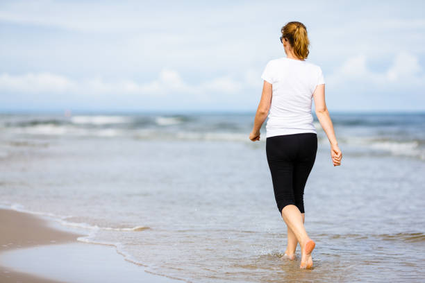 istock Woman walking on beach 959468852