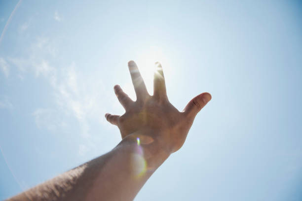 ręka człowieka sięgający do światła słonecznego - catch light zdjęcia i obrazy z banku zdjęć