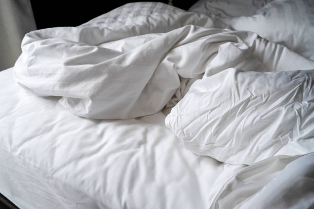 istock Wrinkled blanket white bed and Pillow, morning after wake up. 959473334