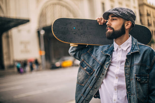 istock Man carrying skateboard on the shoulder 959483192