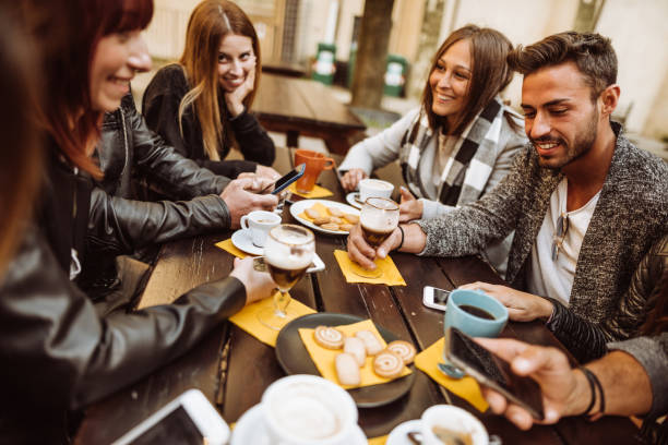 istock friends talking together on a cafe with smartphones 959484344
