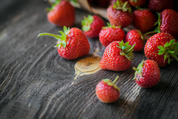 istock strawberry is scattered from a basket on a wooden background 959488354