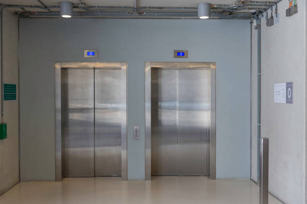 istock Closed elevators with buttons in corridor with concrete walls 959494396