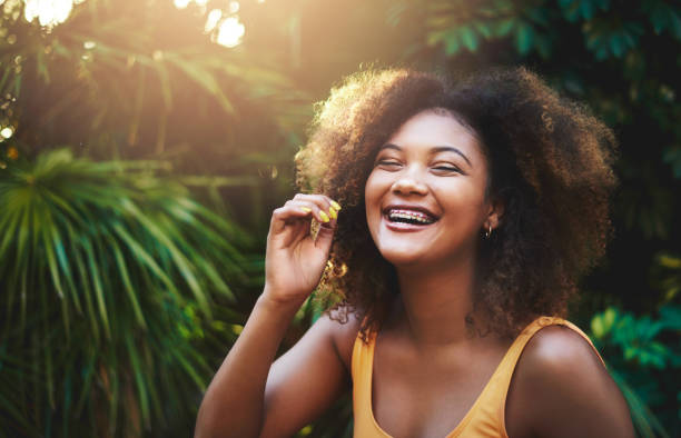 Joy is a beautiful thing that looks great on anyone Cropped shot of a beautiful young woman posing in nature braces stock pictures, royalty-free photos & images