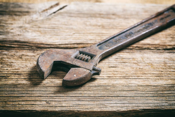 Old used wrench on a wooden surface