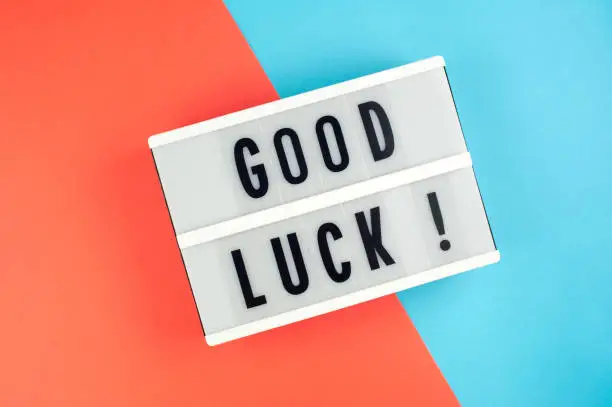 Good luck -  text on a display lightbox on blue and red bright background.