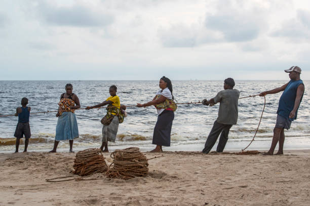 wieśniacy wyciągają sieć rybacką z oceanu, kongo - rowboat fishing africa fishing industry zdjęcia i obrazy z banku zdjęć