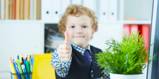 istock Little boy showing thumb up looking into camera and smiling. The 959508700