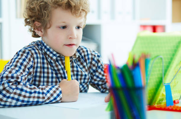 istock Portrait of pupil in school class taking notes during writing le 959508814