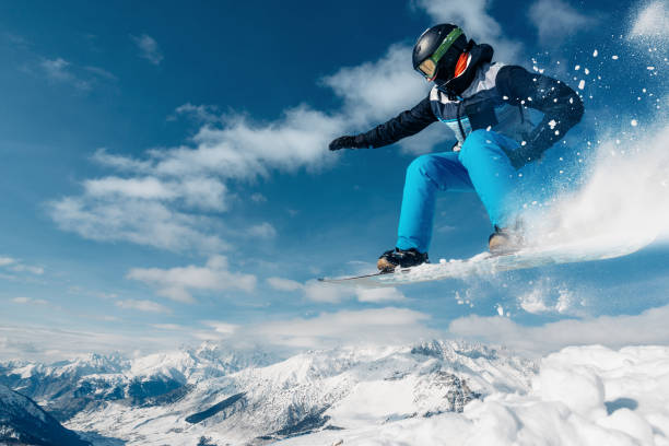istock snowboarder is jumping with snowboard from snowhill 959509240