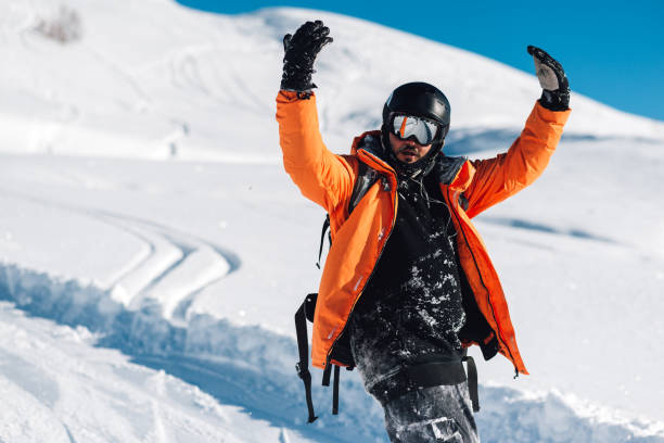 l'uomo felice sta sulla neve - giacca a vento foto e immagini stock