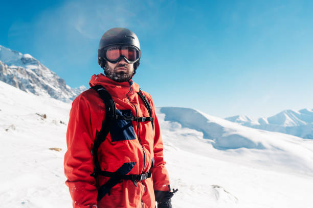 serious snowboarder is standing in the red suit