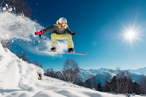 Muchacha es salto con tabla de snowboard photo
