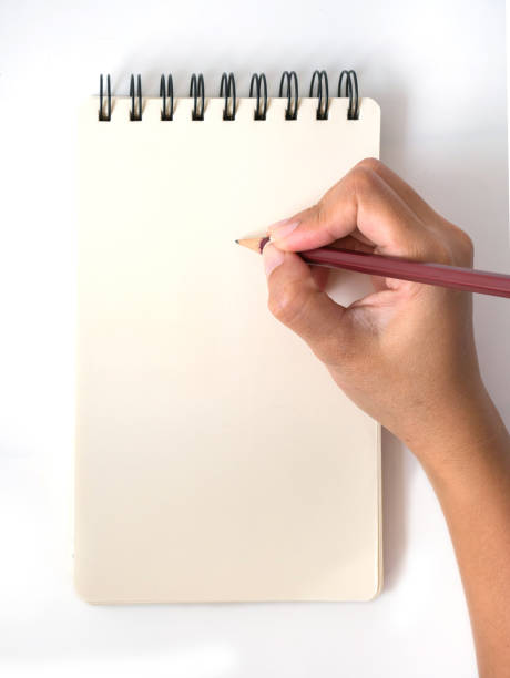 istock Asian female hand with pencil writing on yellow notebook 959512700