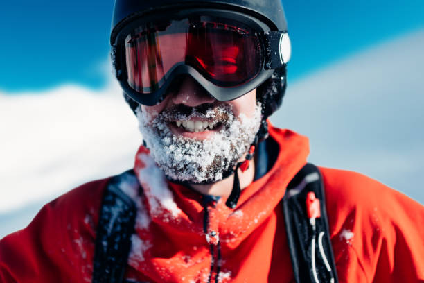 snowboarder feliz está de pie en el traje rojo - snow glasses fotografías e imágenes de stock