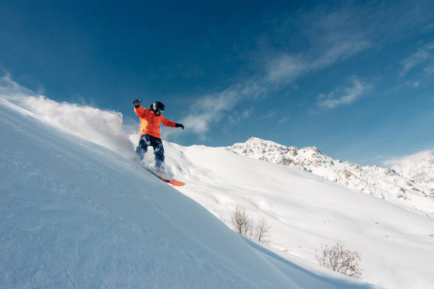 istock snowboarder is riding from snow hill 959513174