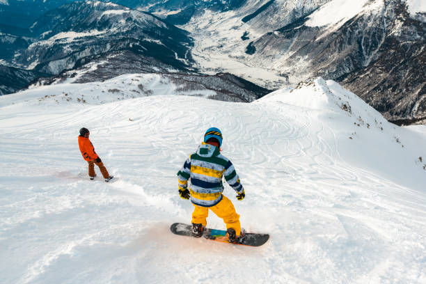 istock snowboarders is riding down of mountain 959513636
