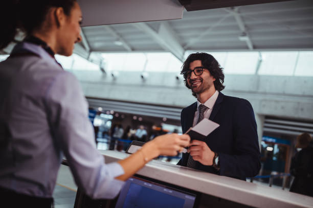 istock Businessman doing check-in and getting boarding pass at airport 959518900