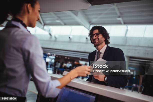 Businessman Doing Checkin And Getting Boarding Pass At Airport Stock Photo - Download Image Now