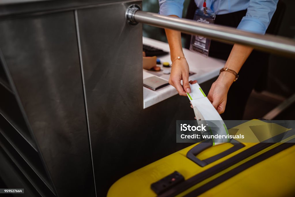 Airport check-in counter employee attaching tag on luggage - Royalty-free Aeroporto Foto de stock