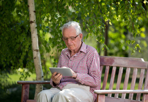 istock Old man with tablet in garden 959528144