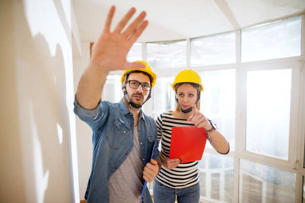 istock A couple of beautiful focused young engineers with helmets on discussing next step. 959531972