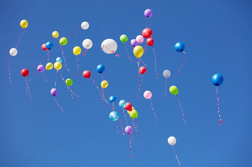 Colored flying balloons in the blue sky
